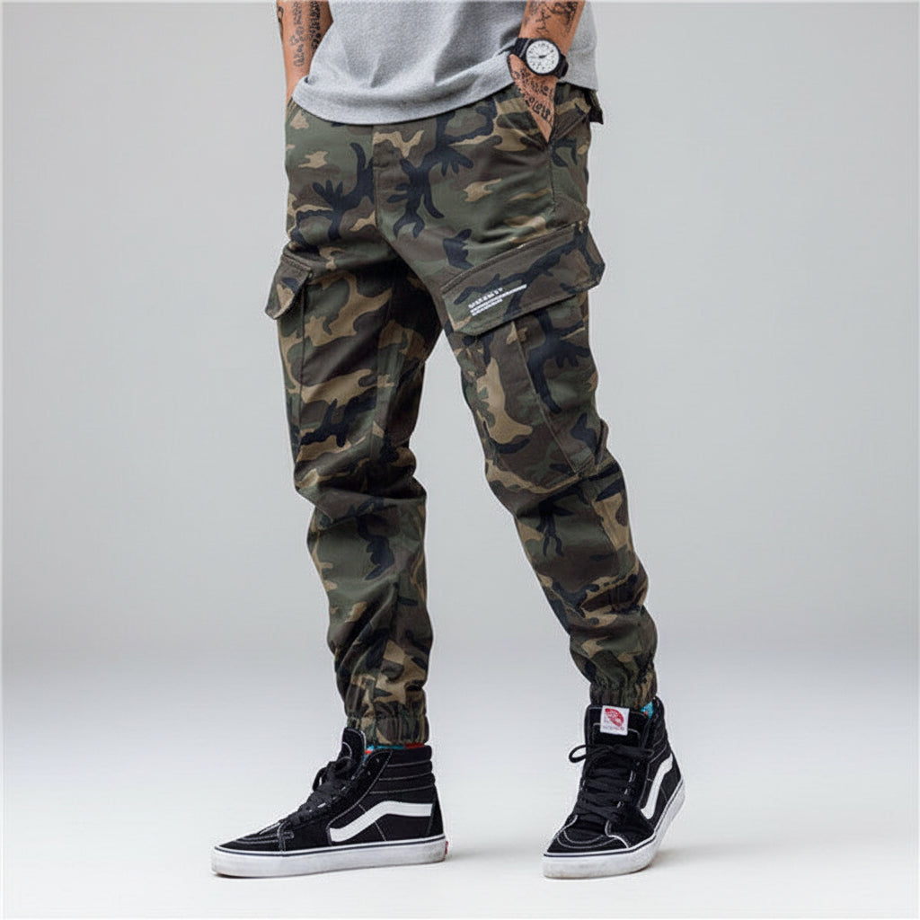 Front view of men’s camo harem jogger pants featuring slim tapered ankle streetwear design