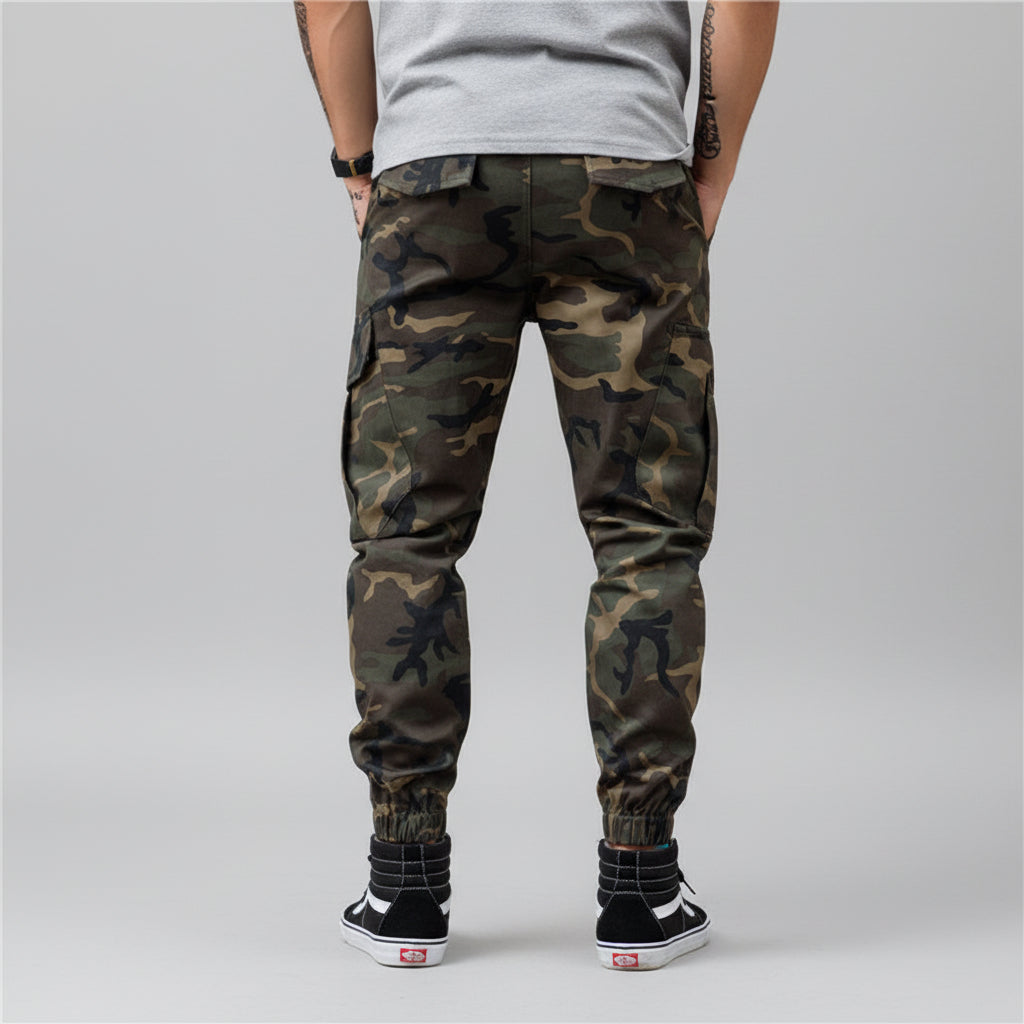 Front view of men’s camo harem jogger pants featuring slim tapered ankle streetwear design